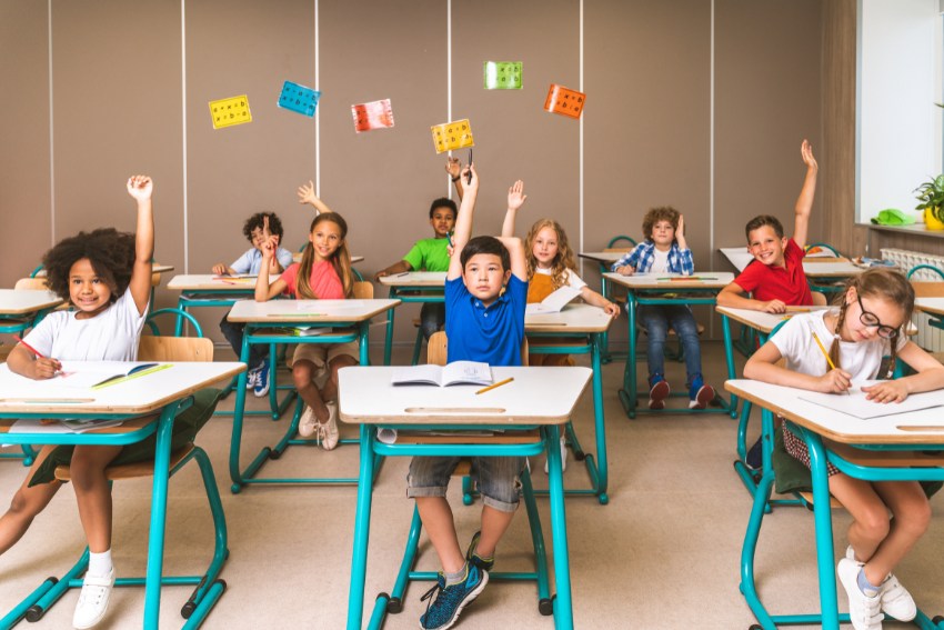Childer in the primary school class rising hands - Top 10 Primary Schools in the UK