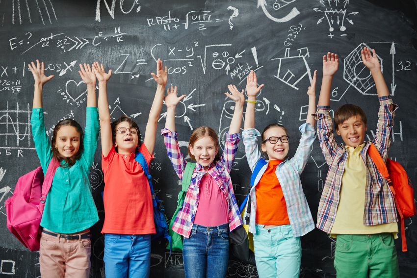 11+ kids in front of the black board